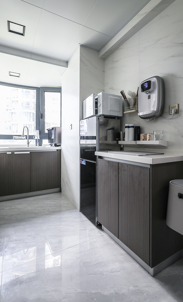 廚房設計兩個操作區，一個是中櫥水斗，一個是西櫥水斗，方便多人一起洗刷，四周白色墻面，中間做大板面磚，空間很活躍，也很實用。