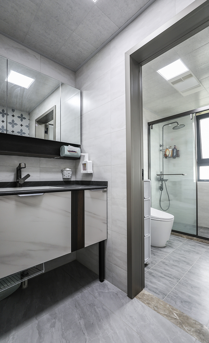 客衛空間很大，彩用干濕分離做法、濕區深灰色地磚，干區藝術磚、白色吊頂，鈦合金移門，體現主人高檔次的生活品味和優雅的審美觀。