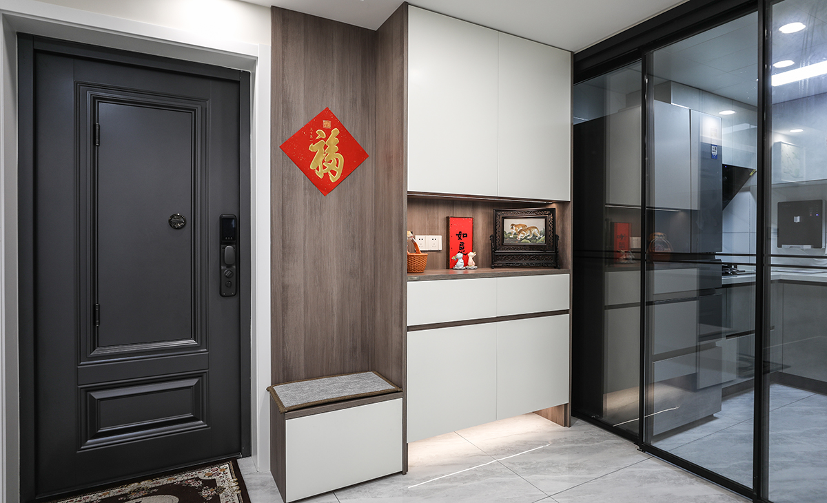 入戶的玄關(guān)柜采取換鞋凳+鞋柜的設(shè)計(jì)，老夫妻畢竟年紀(jì)有點(diǎn)大了，有了換鞋登更加方便生活，鏤空的區(qū)域放鞋，放鑰匙都很方便。
