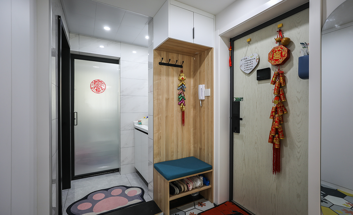 本套房子的玄關設計也是一大亮點，入戶玄關是一個緩存過度地段，門口的換鞋凳方便換鞋，加上掛大衣外套的功能，使空間更加完善。