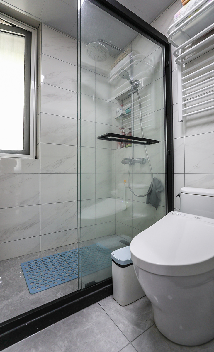 衛生間空間不是很大，彩用干濕分離做法，可以滿足干濕區同時使用，而不影響到對方，地面深灰色地磚，白色吊頂，鈦合金移門，配上衛洗麗馬桶和電熱毛巾架，更加合理的衛浴空間。