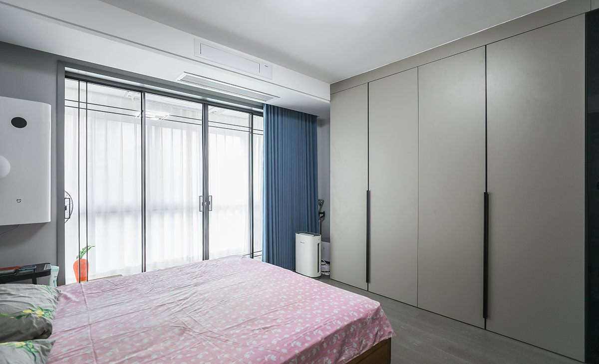 次臥是父母的空間，比較簡潔，做一個L型開放式衣帽間，墻面藍色乳膠漆，色彩上干凈、簡煉，空間上靈活自如，簡潔明亮。