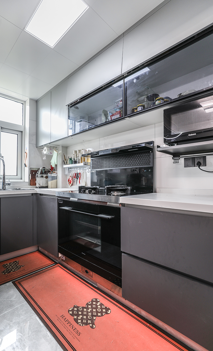 廚房開放式，與餐廳相連，讓主人做飯又可以和客人互動，滿足主人對美食文化的追求，色調上以白色為主，配上黑色電器，高檔有神秘感。