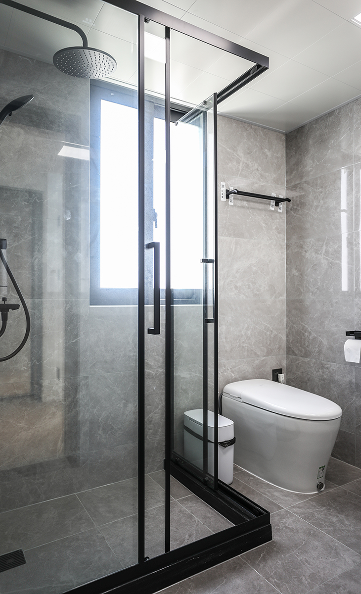 臥室里的衛(wèi)生間，采用L型的直角淋浴房，兩邊都能移動，解決了主人擔心的出入空間狹小的問題，墻地同色的淺灰色瓷地磚搭配，讓整個空間顯得大氣有檔次，滿足了主人的高端品味追求。