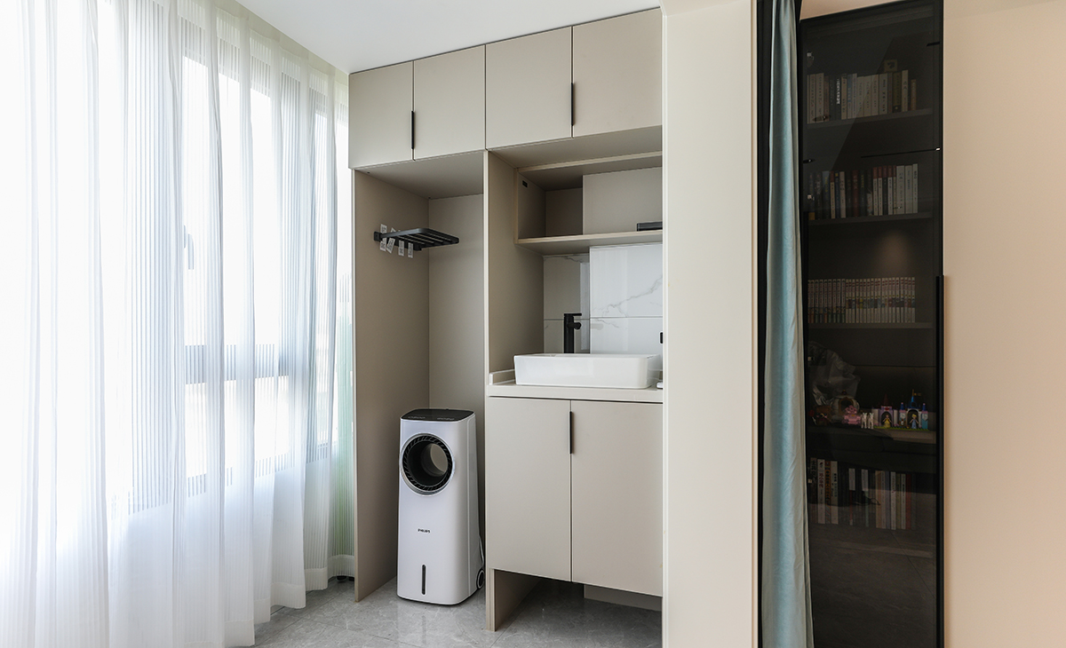 陽臺的一側(cè)是洗衣機和臺盆的組合搭配，用全屋定制柜將整個區(qū)域劃分，不僅可以增加收納，還可以實現(xiàn)空間的合理規(guī)劃，將洗衣，用水，儲物整齊的布局，美觀大氣兼具實用性。