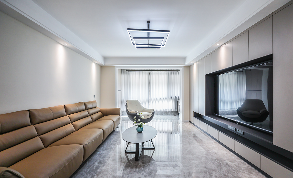 3米多的長沙發，咖色加上原本暖灰的瓷磚，奶咖色的電視柜，顏色統一有層次。