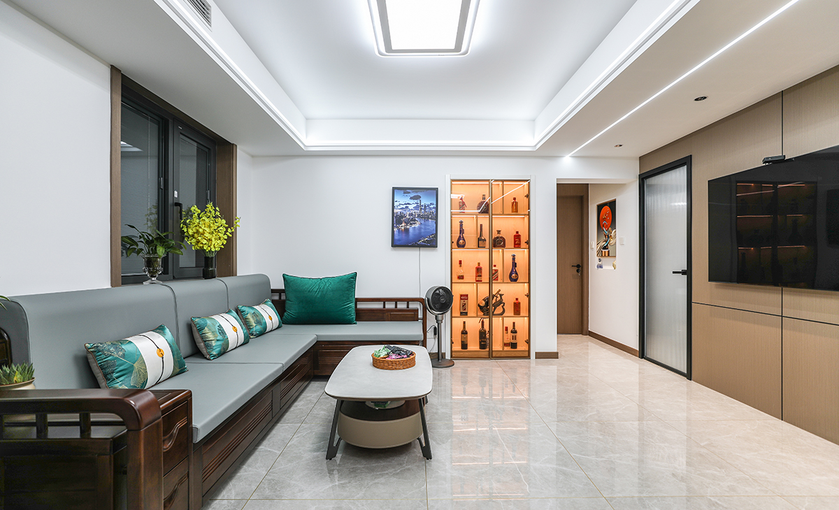 在一個家庭中，客廳是連接內外和溝通客主情感的主要場所，利用頻率較高，所以在空間上也相對比較大?？蛷d比較寬敞，整體墻面用白色乳膠漆，電視墻做木飾面，用原木色木飾面凸出暖色調，明暗相間，實木沙發立刻檔次提高很多，借助原戶型結構，放一組貴妃沙發。地面采用淺灰色地磚，吊頂造型上采用雙眼皮吊頂和線性燈設計。