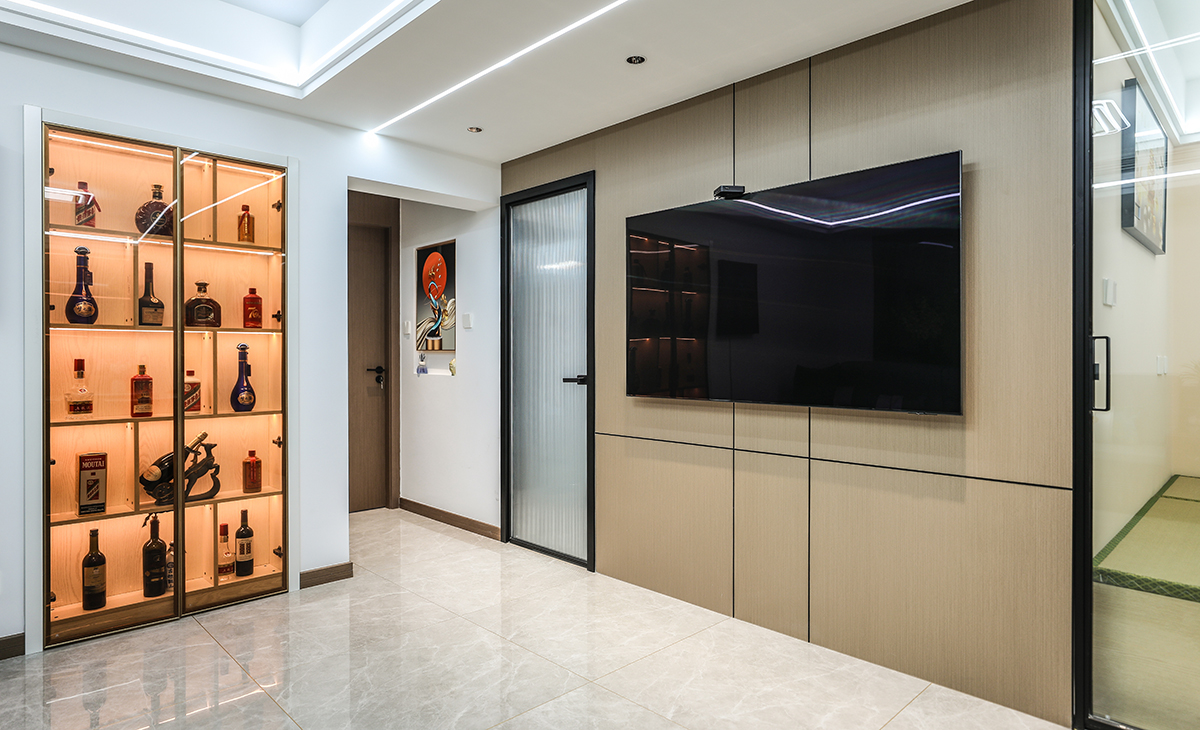 原先門洞的位置改造成酒柜，男主人有收藏酒類的習慣，加上燈光氛圍烘托，也可以當成端景背景使用。