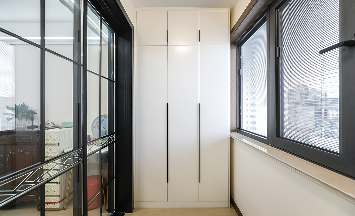 陽臺是晾曬衣物的場所，靠墻做一排到頂為儲物柜，讓空間更加合理的利用起來，顏色以白色為主，儲物柜白色門板和黑色拉手相搭配，即實用又不缺美觀。