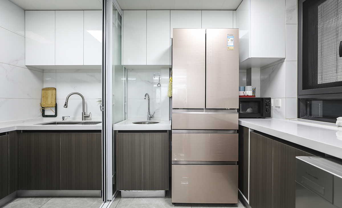 廚房空間很大，簡約的廚房設計，顏色的選擇不會太復雜，白色是常用到元素，使空間有了留白的感受，使用白木與灰木紋色，讓視覺的焦點停留在這上面，線條干凈利落。并且是中西廚兩相結合，中式菜肴在中廚里實用，隔絕了油煙的問題，