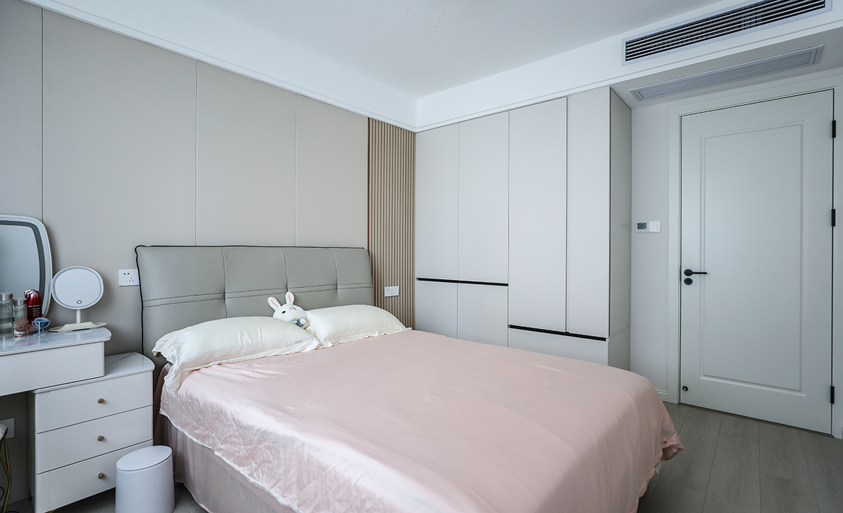 主臥床頭背景和客廳沙發背景一樣采用了同材質來裝飾，做到了統一風格以及色系。地板選用淺色系的灰木紋地板，再配上同色系的床來搭配。讓整個空間顯得干凈簡潔。