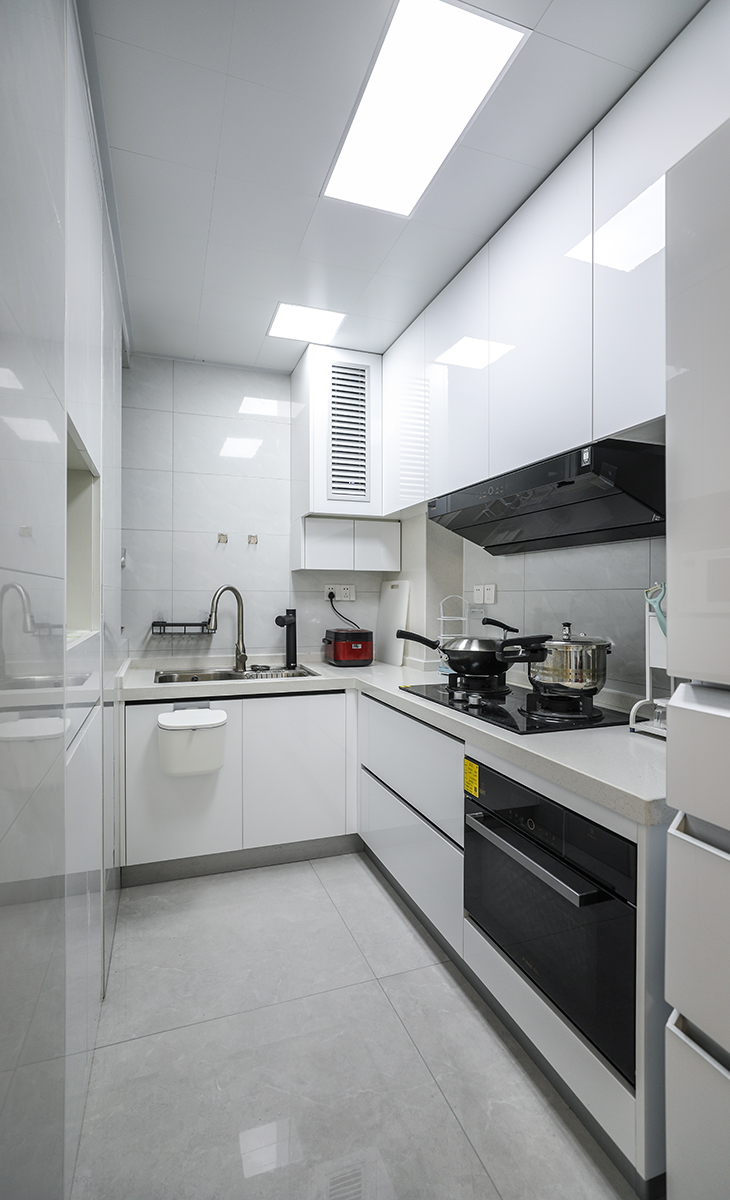 廚房空間很大，L型兩面櫥柜，另外冰箱邊上也有操作臺，顏色簡潔明快，材質要干凈和好打理，白色的吊頂和白色的櫥柜相呼應，石英石臺面經久耐用，各種廚房電器全部配齊，滿足主人制作各種美食的需求。