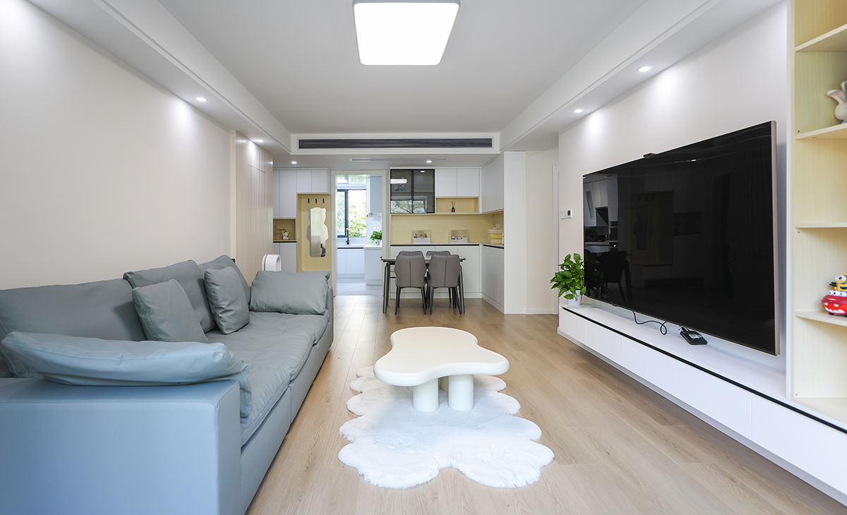 客廳的色彩搭配為墻淺地深的配色理念，這樣對于整體性有不可忽視的效果，沙發的背面做了木格柵裝飾，讓原本單調的墻面有了生機。