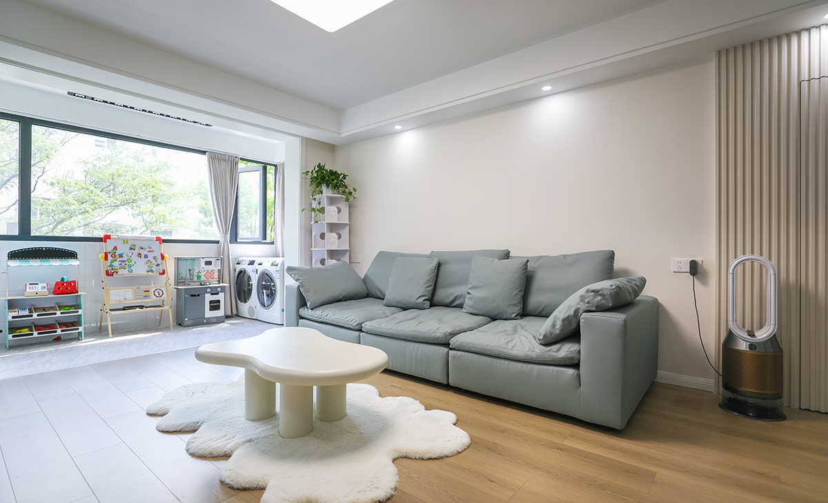 客廳的色彩搭配為墻淺地深的配色理念，這樣對于整體性有不可忽視的效果，沙發的背面做了木格柵裝飾，讓原本單調的墻面有了生機。