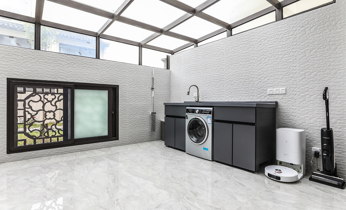 北露臺是晾曬衣物的場所，一側洗衣機和水池，一側為儲物柜，超大玻璃窗讓陽光柔和的照進來，很舒適、很愜意。顏色以白色為主，陽露臺為休閑，白墻黛瓦馬頭墻,回廊掛落花格窗。