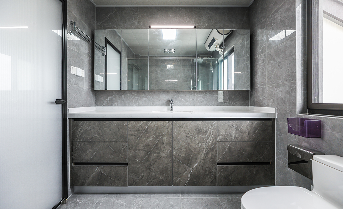 主衛空間也很大，只放一個馬桶，一個洗手臺，做一排儲物柜，增加主人的收納空間，黑色邊框長虹玻璃門，讓整個空間協調統一，大氣時尚，主人很滿意，不斷地夸贊設計師對色彩的精準把握。