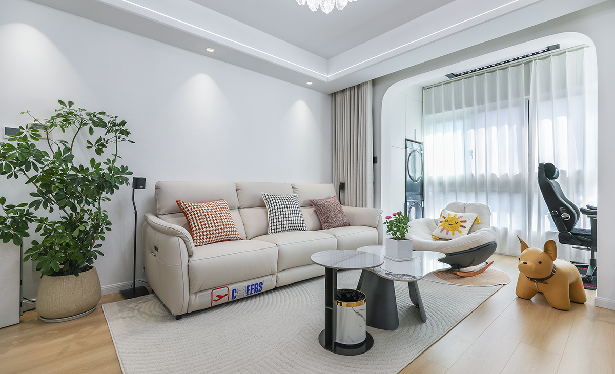 沙發背景刷米白色涂料，米色的沙簾，沙發背景留白設計，色調上墻面涂料和窗簾用淺色，沙發用淺灰色，深淺搭配的錯落有致，既溫馨又簡潔。