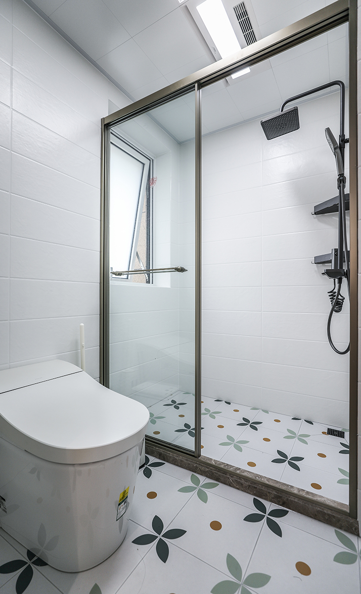 衛生間濕區空間也很大，一個馬桶，一個淋浴房，金色邊框淋浴房，地面藝術花磚，大氣時尚，主人很滿意，不斷地夸贊設計師對色彩的精準把握。