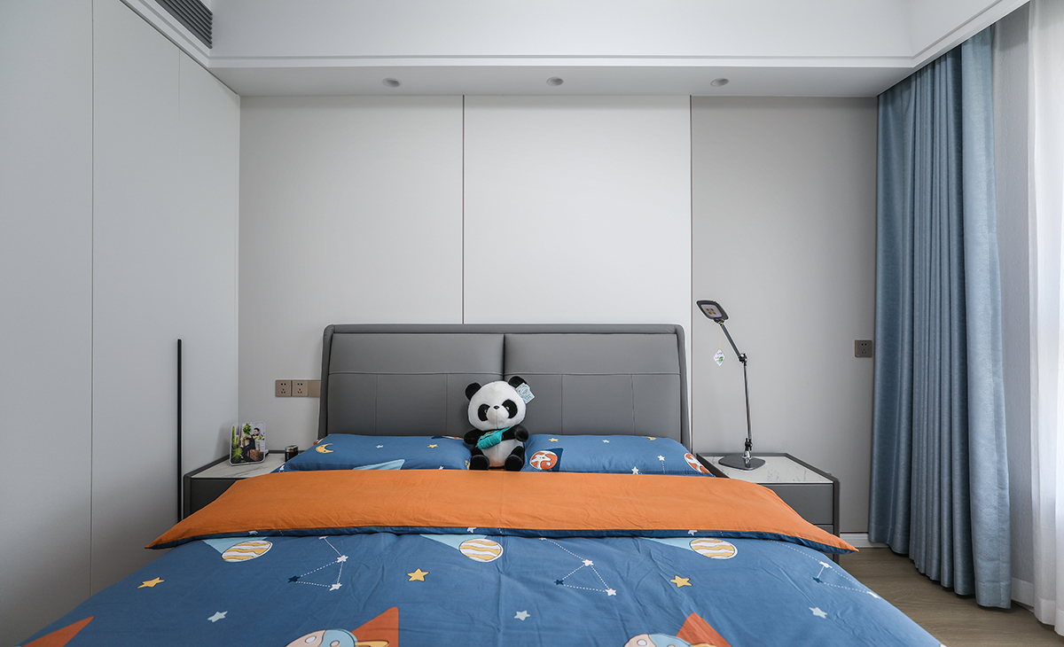 次臥是公子房，1.8米灰色皮包床保證小朋友睡覺充足翻身空間，睡的安心，衣柜區域正對進門區做一排玻璃門，里面可以放小朋友的玩具和書本，床頭背景墻米白色結合淺灰色竹木纖維墻板，既讓奶白色柜門和墻面、頂面渾然一體，同時呼應了灰色床、床頭柜，整個次臥看起來高大尚。