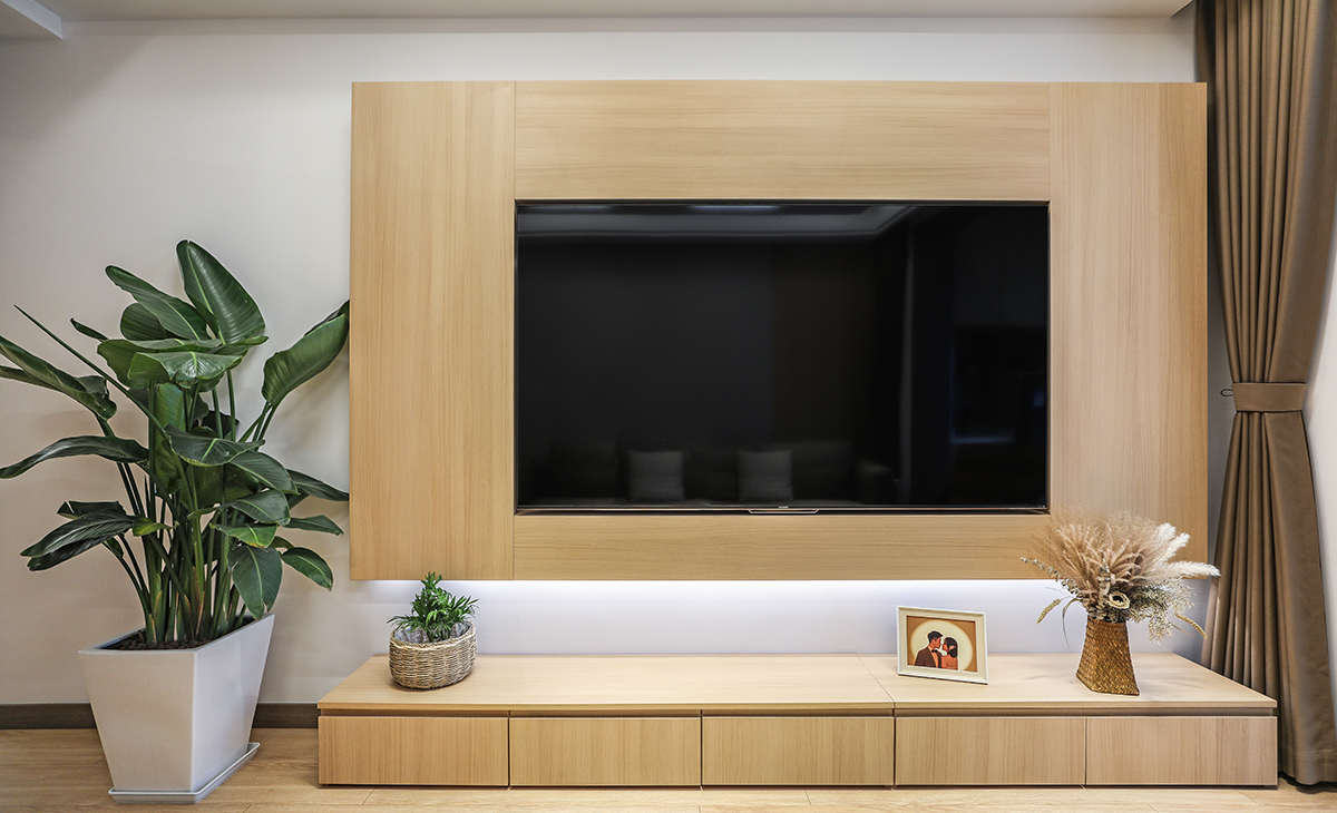 電視背景墻刷下面用的兔寶寶全屋定制柜，下面做了五個抽屜落地，中間用的原木色板材做的背景墻，電視機嵌入式，做懸浮凸出來，用線性燈做點綴，窗簾選用的咖啡色，配上白色的墻面，回歸到大自然的田園生活，深淺搭配的錯落有致，既溫馨又簡潔。