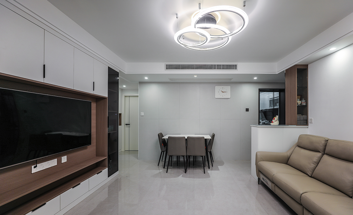 客廳和餐廳連在一起，空間合理規劃將餐廳和客廳分開，風格以簡約風格為主，地面鋪淺灰色的80*80的地磚，頂面做中央空調，整個的吊頂以簡約的線條為主。