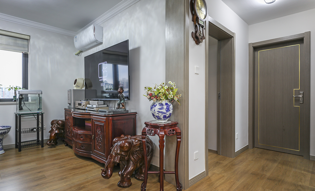 視和沙發調整位置，進門就能看到電視墻而不是沙發，隱私效果和裝飾效果會更好，不做復雜的背景墻，電視柜兩邊的裝飾盆景作襯托，讓空間不但時尚而且清爽。