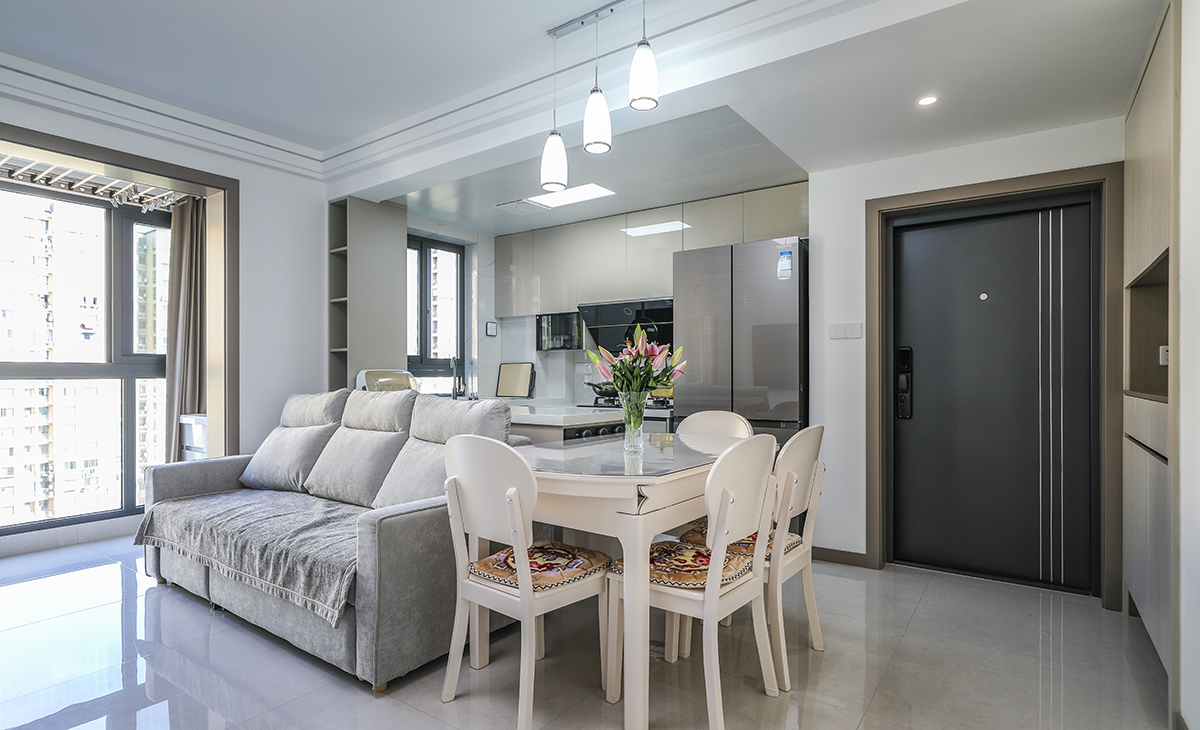 餐廳空間比較方正寬敞，正好靠著沙發，進門靠墻做一排鞋柜，既實用又美觀，巖板餐桌把用餐氛圍調和的很溫暖，淺灰色地磚很干凈，色彩和造型上都簡潔大氣。