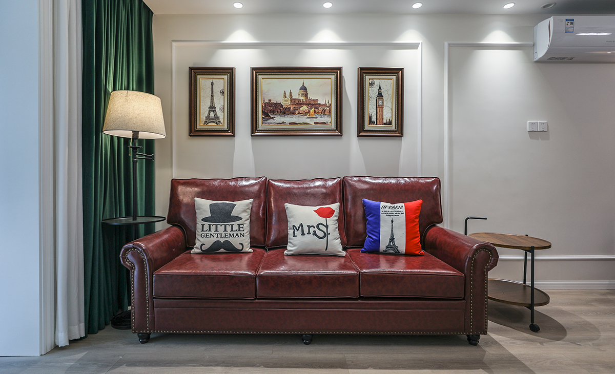 高飽和度的皮質沙發(fā)把復古的格調演繹出來，吊燈和落地燈的選擇都共同打造油畫一樣的美感氛圍。暖色調的墻漆和地面瓷磚相呼應，懸掛背景墻上的裝飾畫更是恰到好處，精心挑選的畫框和位置，提升整體設計效果。美式復古風的濃郁風情在這個客廳的種種細節(jié)里，體現的非常充分。