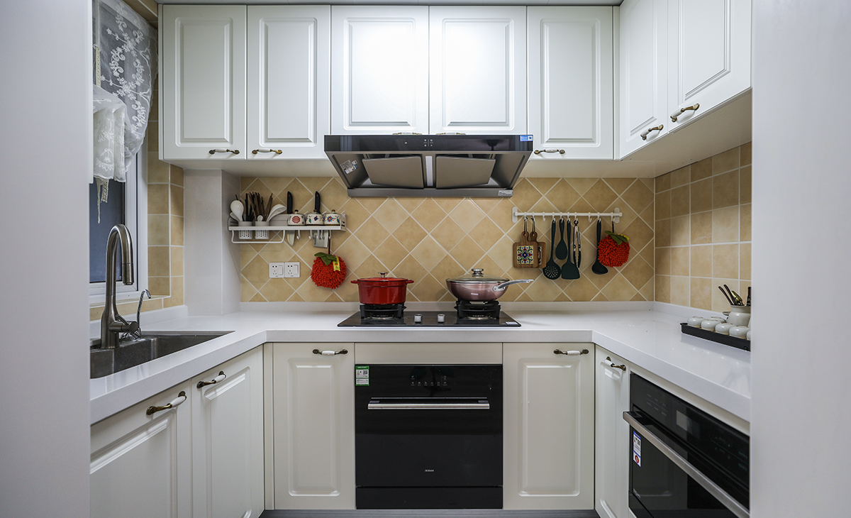 U型櫥柜滿足業(yè)主喜歡做飯的需求，棋盤格地磚讓整體不顯單調，?淺的地柜做開放式，可以放一些瓶瓶罐罐。