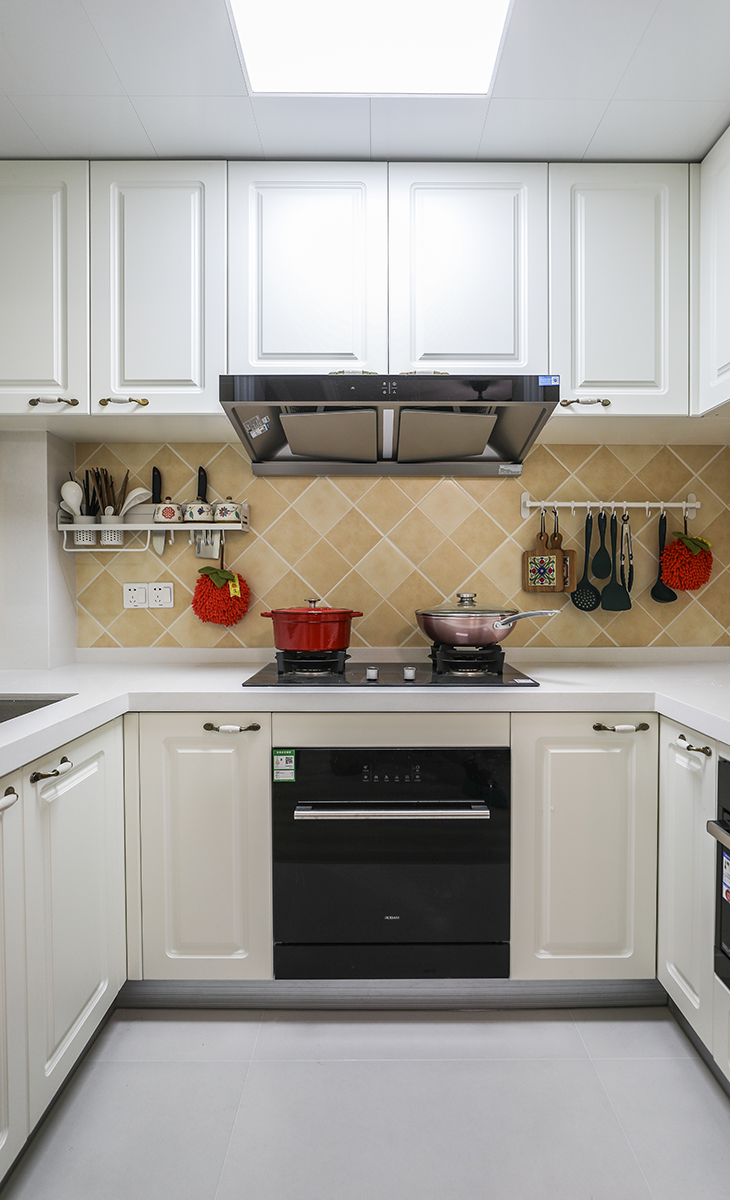 U型櫥柜滿足業(yè)主喜歡做飯的需求，棋盤格地磚讓整體不顯單調，?淺的地柜做開放式，可以放一些瓶瓶罐罐。