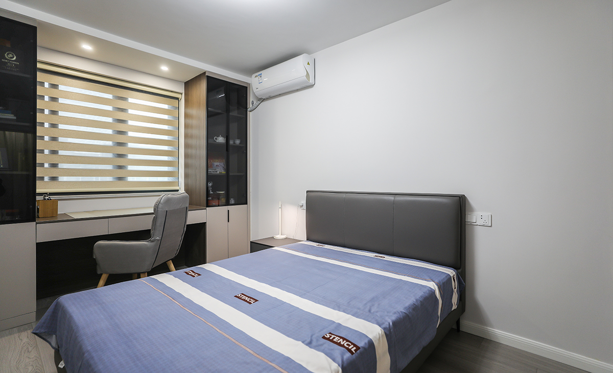 次臥整體采用了簡約自然的風格，白色墻壁和木地板的搭配，給人一種溫馨舒適的感覺。家具方面，選擇了一張床、一個書桌、一個椅子，簡潔實用，符合現代人追求簡約的生活方式。在色彩上，以白色主，營造出一種自然清新的氛圍。整個設計注重細節，比如床頭燈、裝飾畫等小物件，都為臥室增添了一些溫馨和浪漫的氣息。