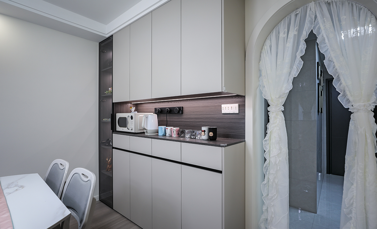 本套房子的玄關設計也是一大亮點，入戶玄關是一個緩存過度地段，門口的換鞋柜方便換鞋，使空間更加完善，中間和下方漏空的鞋柜，隨手可以放置包包，鑰匙等，既實用，又有裝飾性。