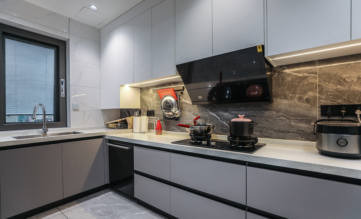 廚房間整體空間很大，業主對烹飪要求很高，洗碗機、蒸烤箱都需要，臺面選用了2公分的魚肚白石英石，做了高低臺面，使用起來方便也好打理。