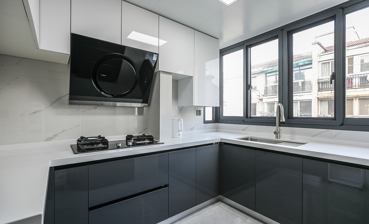 該套房子廚房空間很大，L型兩面櫥柜，另外冰箱邊上也有操作臺，顏色簡潔明快，材質要干凈和好打理，白色的吊頂和米色的櫥柜相呼應，各種廚房電器全部。