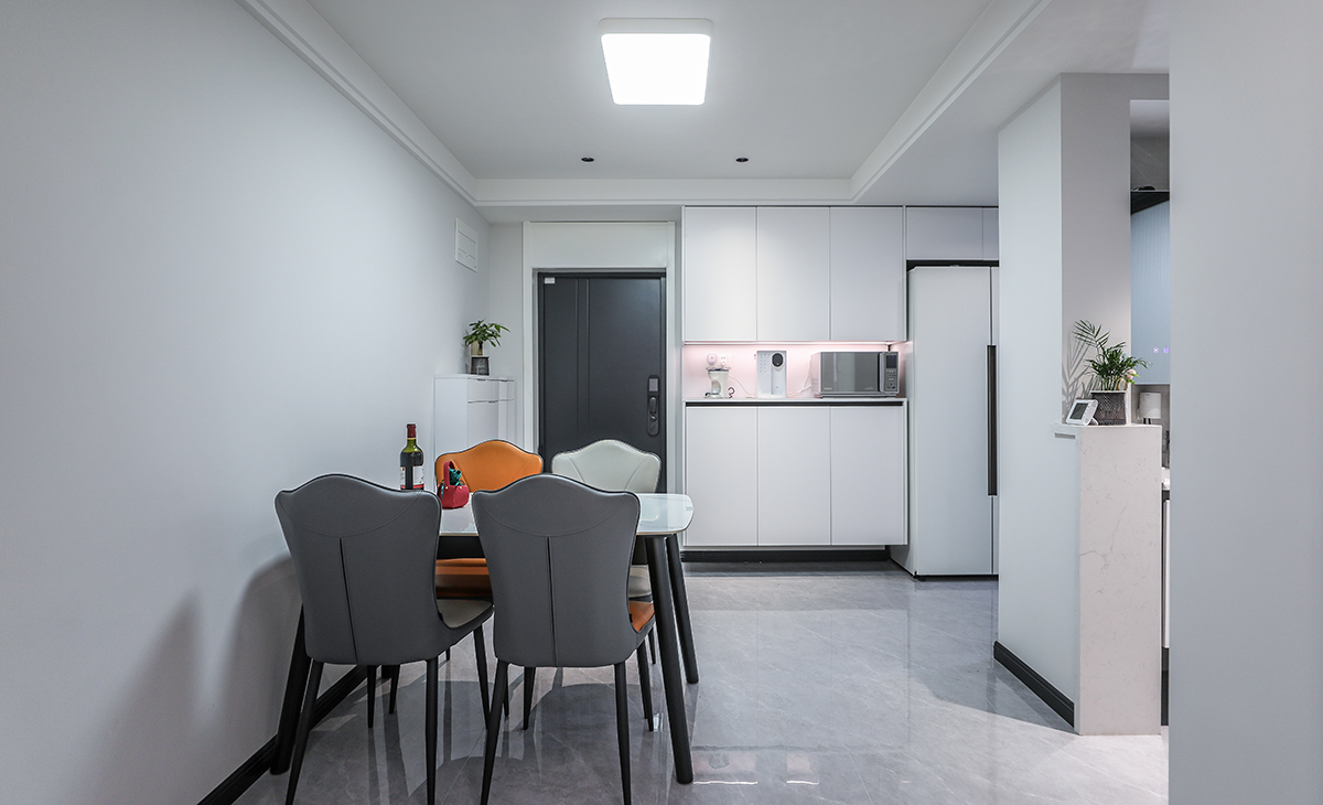 餐廳空間比較方正寬敞，靠入戶門做一排餐邊柜兼鞋柜，既實(shí)用、又有裝飾功能，白色框架板及白色門板配黑色踢腳線顏色相互襯托，巖板餐桌把用餐氛圍調(diào)和的很溫暖，淺灰色地磚很干凈，色彩和造型上都簡(jiǎn)潔大氣。