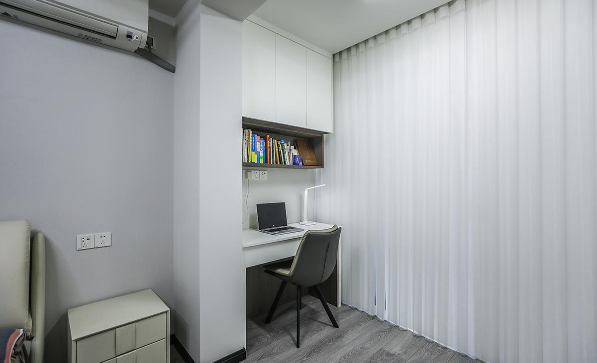 陽臺(tái)是主人的辦公場(chǎng)所，寫字臺(tái)及吊柜的組合，顏色以白色為主，儲(chǔ)物柜白色門板和黑色角線相搭配，配備白色一席紗簾若影若現(xiàn)，很舒適、很愜意。