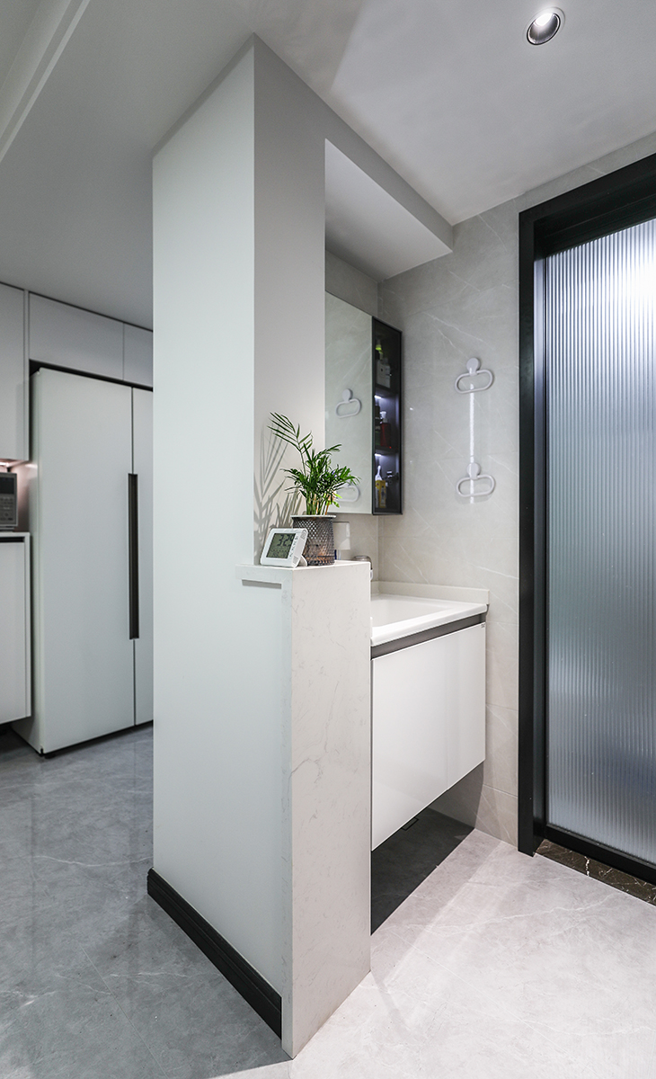 衛(wèi)生間采用了干濕分離布局，臺(tái)盆做了90公分壁掛洗手臺(tái)及鏡柜，既滿足了客戶的儲(chǔ)物空間也增添了美感，滿足了早高峰上廁所和洗漱的同時(shí)需求。半高墻的大理石臺(tái)面也更體現(xiàn)主人高檔次的生活品味和優(yōu)雅的審美觀。