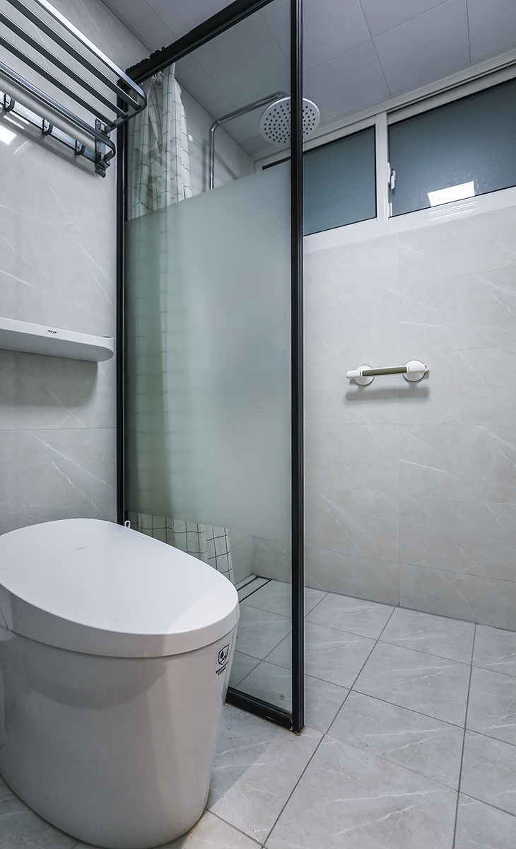 濕區(qū)，只放一個(gè)馬桶和淋浴區(qū)域，黑色邊框鋼化玻璃屏風(fēng)隔斷，讓整個(gè)空間協(xié)調(diào)統(tǒng)一，大氣時(shí)尚，主人很滿意，不斷地夸贊設(shè)計(jì)師對(duì)色彩的精準(zhǔn)把握。