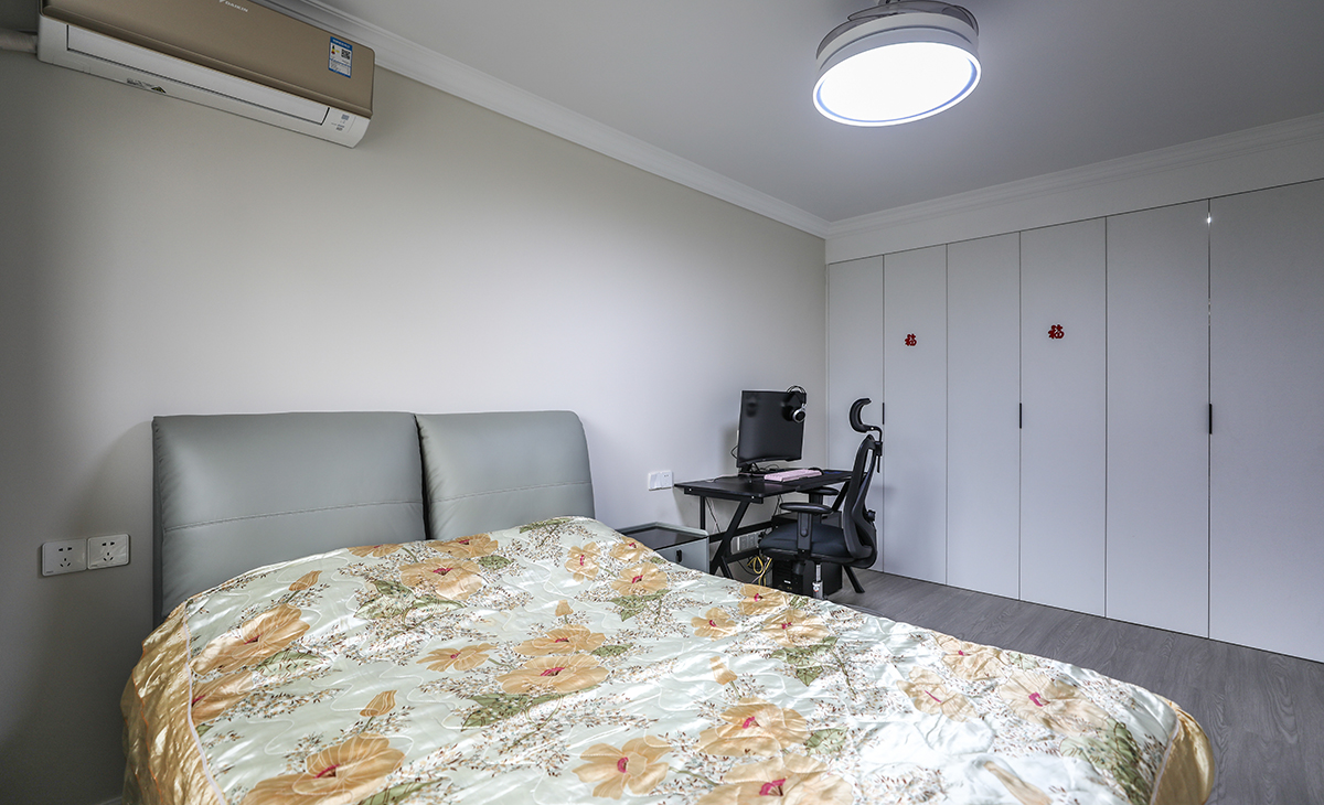 主臥地板亦采用了灰色，因為整體簡約為主，所以個別材質會特別豐富，比如衣柜門板乳白色為主，和淺灰色地板進行搭配，床又以皮質材質為主，既有層次又不突兀，頂面圓型吊扇燈，實現方中有圓，圓中有方，造型以簡潔平板為主，方便

 打理，體現了簡約風格的簡潔、隨意，不拘一格。