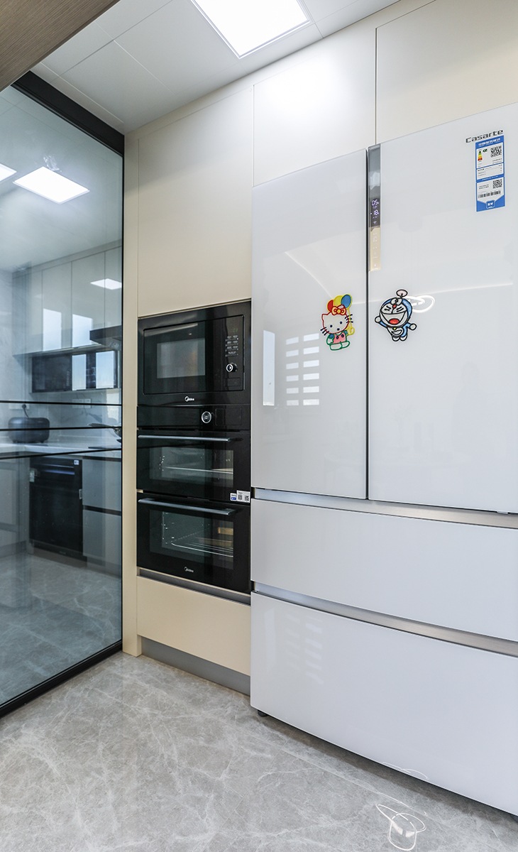 該套房子廚房空間很大，做成干油分離，把冰箱和蒸箱、烤箱等電器放在移門外面，不會有油膩，方便打理，大雙門冰箱滿足儲物空間。