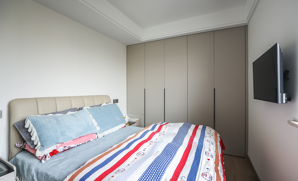 次臥小夫妻兩居住，靠床頭柜的柜門采用上下門，再也不會被床頭柜擋住而開不了門的情況了。地板原木色，墻面頂面白色乳膠漆，既簡單又實用。