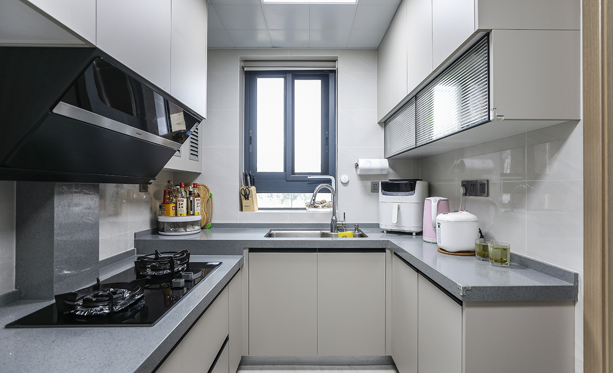 　　該套房子廚房空間很大，U型三面櫥柜，臺面錯層，洗碗再也不累腰。顏色簡潔明快，材質要干凈和好打理，白色的吊頂和米色的櫥柜相呼應，吊柜雙層儲物，調料罐罐都有地方可放。各種廚房電器全部配齊，滿足主人制作各種美食的需求。