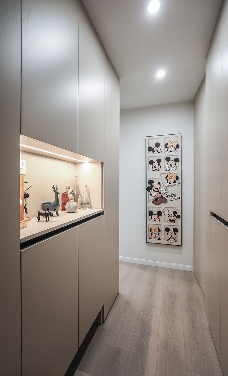 進戶的落塵區（玄關區）有效的增加了進門放鞋子以及鞋柜對面隱藏式的掛衣區，因為空間結構問題，掛衣區旁邊增加一個雜物間，并做隱形門設計。