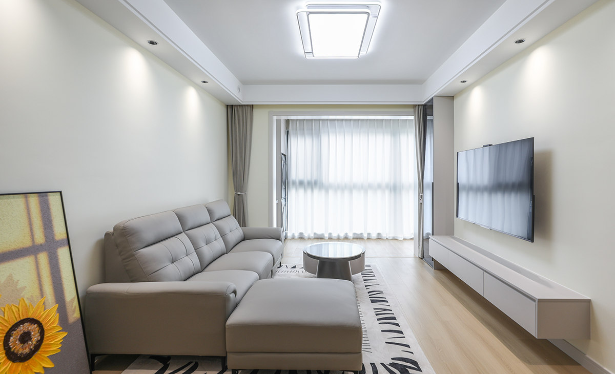  窗簾顏色和沙發相呼應，和白色陽臺門套相配襯，電視立柜與懸空柜的裝飾，讓空間活躍很多，通長電視柜也很大氣，沙發旁搭配的向日葵壁畫，讓整個空間呈現