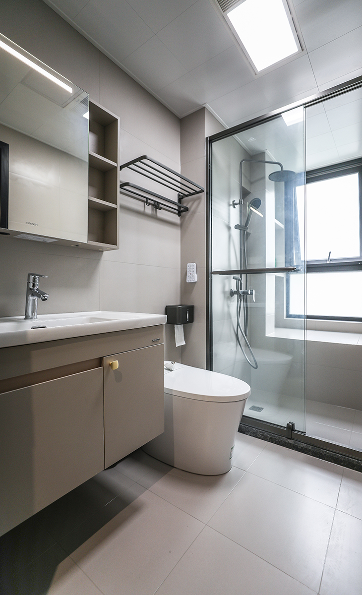 主衛生間不大，黑色淋浴房邊框、白色馬桶，墻地一體柔光磚、白色吊頂，長虹玻璃鈦合金移門，體現主人高檔次的生活品味和優雅的審美觀。