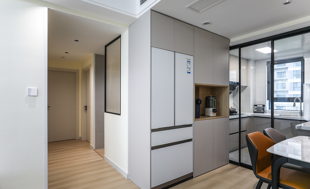 餐邊柜采用組合柜形式，0嵌的卡薩帝冰箱搭配鏤空的電器臺面，咖啡機，榨汁機等，1300*650的餐桌，平時家里只有2-3個人吃飯，夠主人用，白色巖板臺面，黑色餐桌腳，愛馬仕橙的椅子，搭配上方筒燈，靈活輕巧。