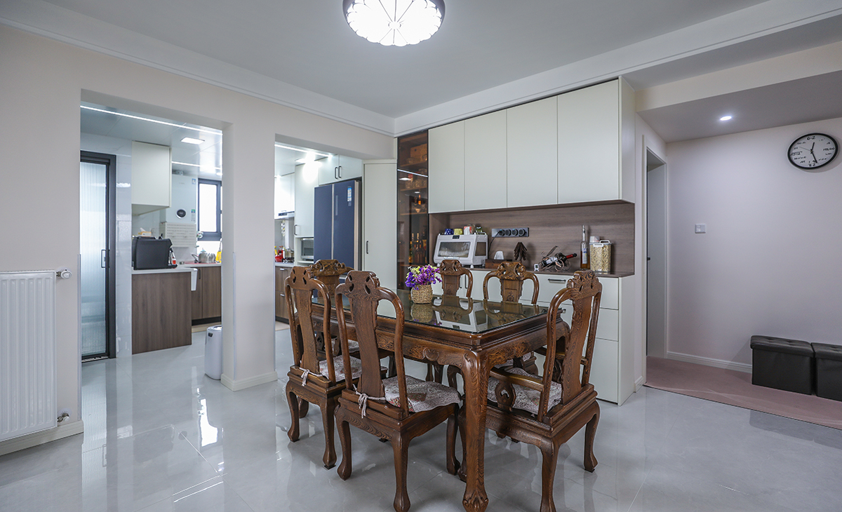 餐廳靠墻做一排裝飾柜，既實用、又有裝飾功能，極大的滿足了客戶的儲物多需求。深棕色框架與餐桌椅相呼應，淺灰色地磚很干凈，色彩和造型上都簡潔大氣。