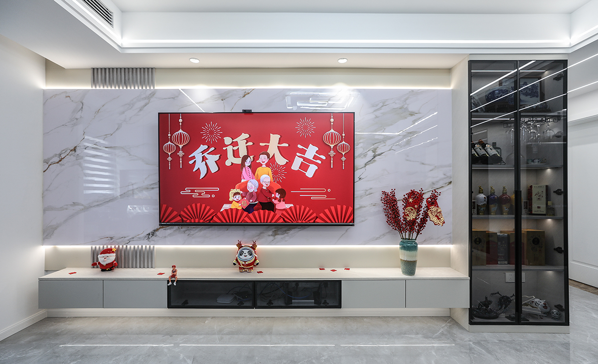 超大的巖板背景墻，頂上二個(gè)射燈點(diǎn)綴的恰到好處，加上木質(zhì)格柵的搭配給整個(gè)背景墻增加一番優(yōu)雅，電視邊柜采用透明黑色玻璃高端又大氣，電視柜也采用了懸空做法，讓空間不但時(shí)尚而且清爽。