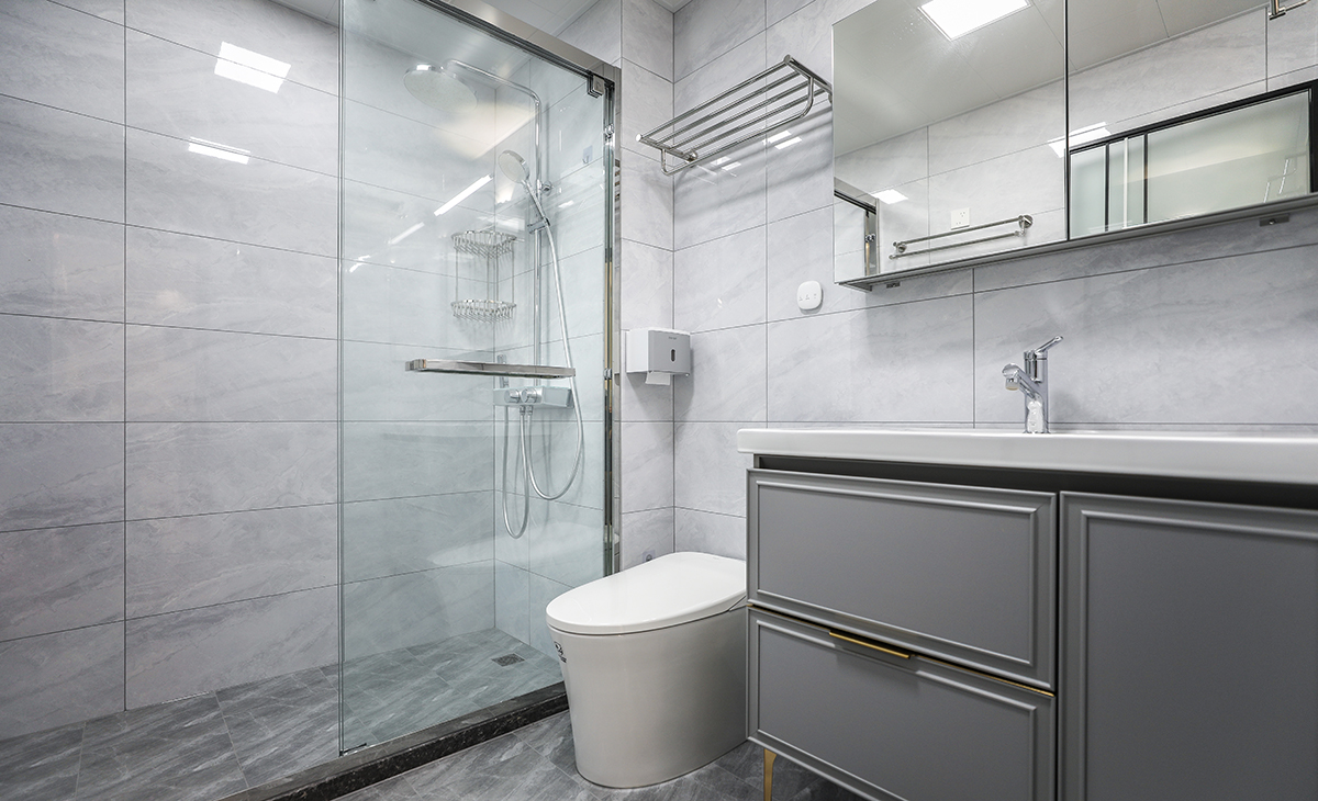 主衛(wèi)生間不大，不銹鋼本色淋浴房邊框、白色馬桶，墻地一體柔光磚、白色吊頂，長虹玻璃鈦合金開門，體現(xiàn)主人高檔次的生活品味和優(yōu)雅的審美觀。