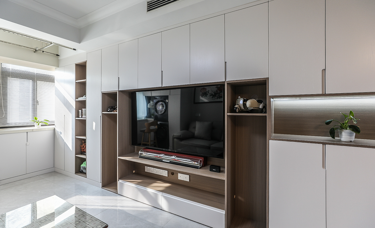 進(jìn)戶鞋柜與電視柜整體做成一體式的柜體，設(shè)計(jì)采用下方和中間漏空，下方放鞋，中間放工藝品，讓鞋柜功能齊全，顏色和防盜門(mén)、進(jìn)戶門(mén)套能夠協(xié)調(diào)。